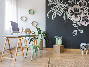 Chalkboard_feature_wall_study_flower_artwork_timber_floorboards_desk_woven_rug_green_chair